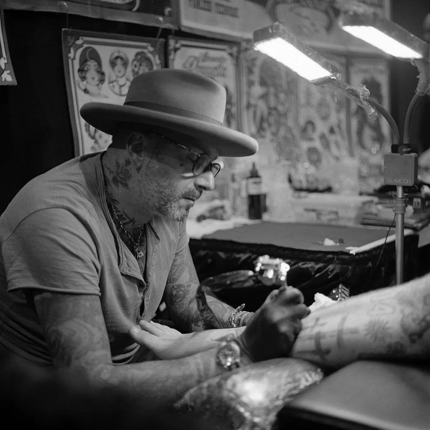 Alessandro Pennella al lavoro, col cappello, chino sul tatuaggio: bianco e nero.