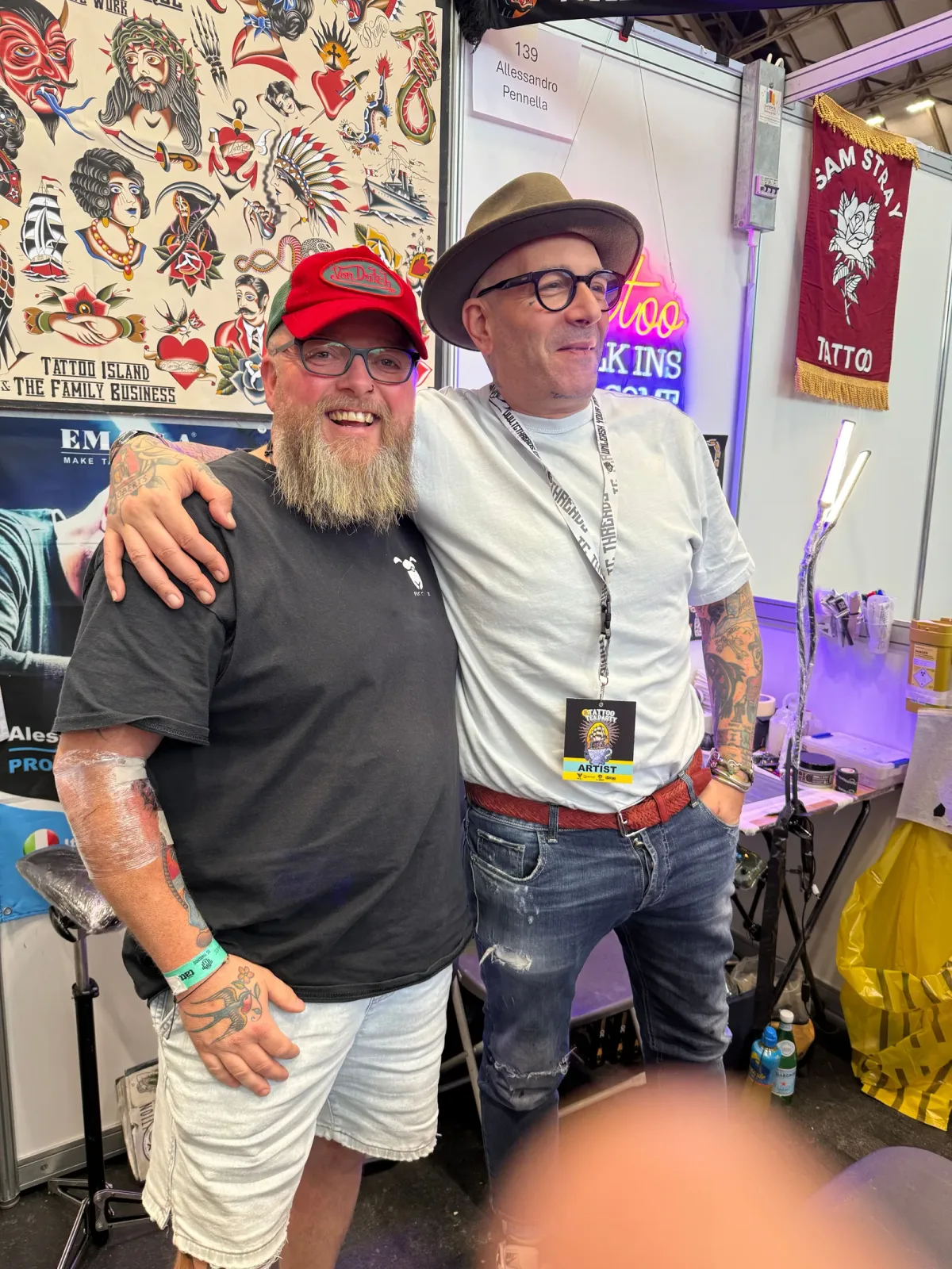 Alessandro Pennella at his convention booth, in front of the Tattoo Island · The Family Business banner.