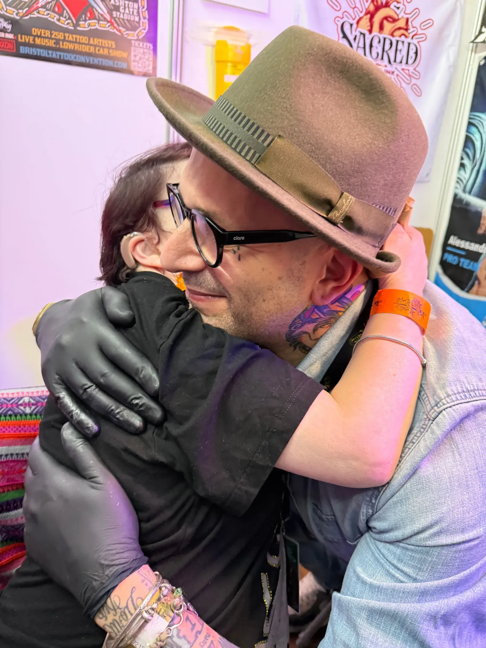Alessandro Pennella being hugged at the end of a session, at the Bristol Tattoo Convention.