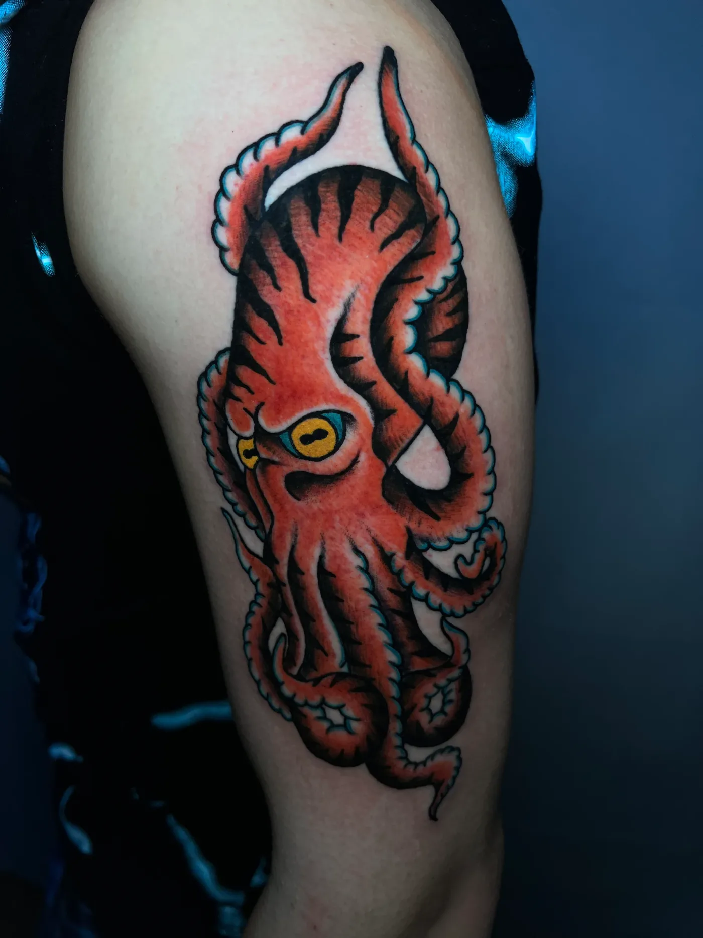 Un polpo rosso con i tentacoli aperti, sulla coscia.